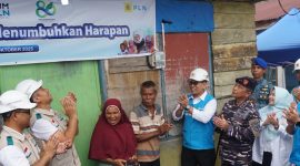 Momen penyalaan sambungan listrik program “Berbagi Cahaya, Menumbuhkan Harapan” oleh Direktur Manajemen Risiko PLN, Adi Lumakso (ketiga dari kanan), di rumah salah satu penerima manfaat, Nazaruddin (tengah). Rasa haru dan bahagia terpancar dari pasangan suami istri ini saat rumah mereka akhirnya memiliki sambungan listrik mandiri.