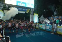 Direktur Utama PLN, Darmawan Prasodjo (belakang memegang bendera) bersama jajaran Direksi dan Komisaris PLN melepas para peserta Kategori Half Marathon PLN Electric Run 2025 di garis start.