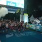 Direktur Utama PLN, Darmawan Prasodjo (belakang memegang bendera) bersama jajaran Direksi dan Komisaris PLN melepas para peserta Kategori Half Marathon PLN Electric Run 2025 di garis start.