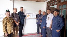 Direktur Manajemen Human Capital dan Administrasi PLN NP TB Ari Wibawa Mukti  (ketiga dari kiri) bersama Sutarno (keempat dari kiri) memegang plakat yang menjadi penanda selesainya renovasi rumah purna  karya PLN NP tersebut.