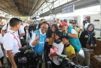 Direktur Legal dan Manajemen Human Capital PLN, Yusuf Didi Setiarto saat melakukan swafoto bersama salah satu keluarga yang menjadi peserta Mudik Gratis BUMN sebelum diberangkatkan dari Stasiun Pasar Senen, Jakarta pada Selasa (17/3).