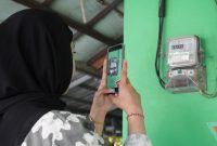 Ilustrasi pelanggan tengah memanfaatkan fitur SwaCAM di aplikasi PLN Mobile untuk mencatat stand meter listrik secara mandiri pada tanggal 23 hingga 27 setiap bulannya. Fitur ini memudahkan pelanggan pascabayar dalam memantau pemakaian listrik dan memperkirakan tagihan dengan lebih jelas.