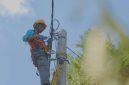 Petugas PLN melakukan penyambungan listrik tegangan rendah agar dapat melistriki rumah rumah masyarakat di Dusun Noemuke.