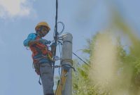 Petugas PLN melakukan penyambungan listrik tegangan rendah agar dapat melistriki rumah rumah masyarakat di Dusun Noemuke.
