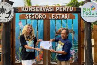 Pengunjung yang berpartisipasi menjadi relawan dalam kegiatan konservasi di Konservasi Penyu Segoro Lestari Blitar mendapatkan piagam penghargaan yang diserahkan Sardi selaku Ketua Kelompok Konservasi Penyu Segoro Lestari.