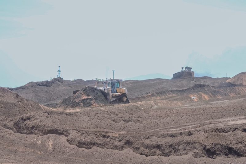 Proses pencampuran (mixing) batubara dengan biomassa jenis sawdust (serbuk gergaji kayu) di area stockpile PLTU Paiton, Probolinggo, Jawa Timur, sebagai bagian dari implementasi program cofiring biomassa untuk mendukung transisi energi dan pengurangan emisi karbon.